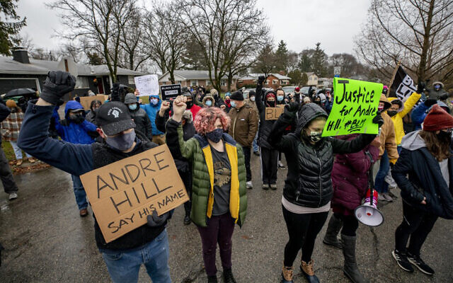 Protesters observe a moment of silence during a demonstration against the police killing of Andre Maurice Hill in the neighborhood where he was shot, in Columbus, Ohio, December 24, 2020. (Stephen Zenner/AFP)