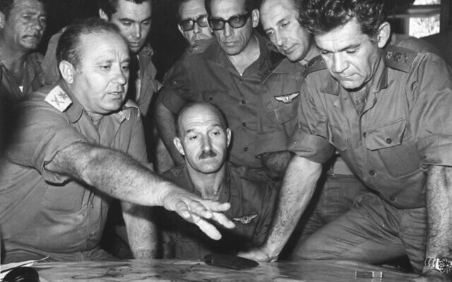 Then-head of the IDF Northern Command Maj. Gen. Yizhak Hofi, left, speaks to then-IDF chief of staff David Elazar, right, and other IDF top officers during the 1973 Yom Kippur War, in an undated photograph. (Defense Ministry Archive)