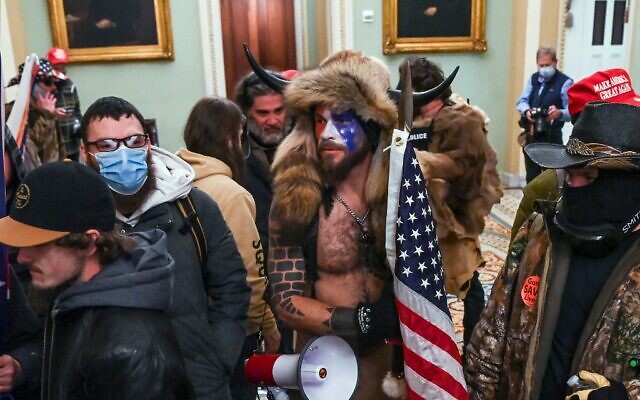 Supporters of US President Donald Trump, including Jake Angeli (aka Jacob Chansley), a QAnon supporter, enter the Capitol in Washington, DC, on January 6, 2021. (Saul Loeb/AFP)