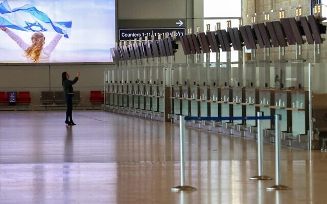 A woman takes a photo at the deserted departure hall at Israel's Ben-Gurion International Airport in Lod, near Tel Aviv, on January 25, 2021. (Emmanuel DUNAND / AFP)