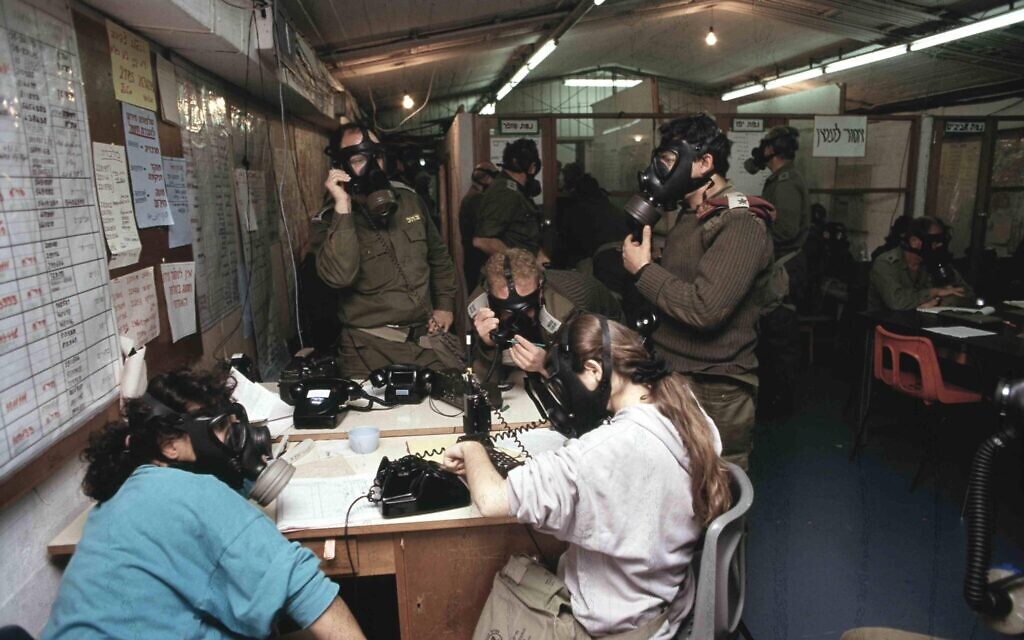 Military officials in a command center wear gas masks during a Scud missile attack on Israel during the 1991 First Gulf War. (Noam Wind, Asaf Topaz and Michael Tzarfati/Defense Ministry Archive)
