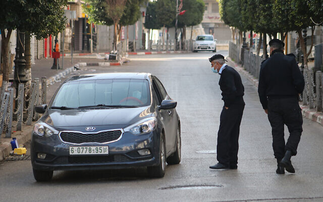 Illustrative: Palestinian police check cars in Ramallah as part of enforcing a coronavirus lockdown on January 1, 2021. (WAFA)