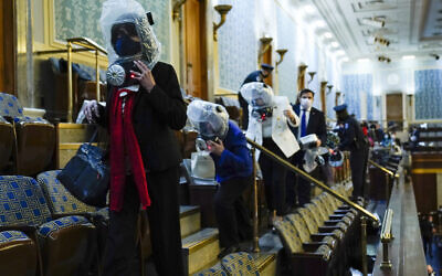 People shelter in the House gallery as protesters try to break into the House Chamber at the US Capitol on Wednesday, Jan. 6, 2021, in Washington. (AP Photo/Andrew Harnik)