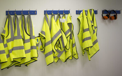 Illustrative: Safety jackets hang at a factory in southern Israel on March 13, 2018. (AP/Ariel Schalit)