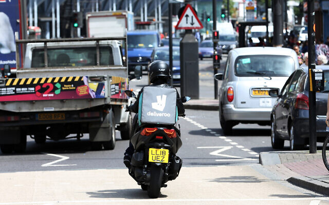 Illustrative: A Deliveroo driver is seen in traffic in north London, June 15, 2018. (AP Photo/Robert Stevens, File)