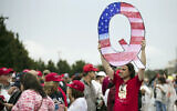 In this Aug. 2, 2018, file photo, a protesters holds a Q sign waits in line with others to enter a campaign rally with President Donald Trump in Wilkes-Barre, Pa.  (AP Photo/Matt Rourke)