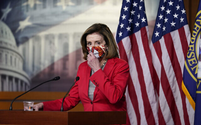 House Speaker Nancy Pelosi adjusts her face mask as she speaks to the media, Dec. 30, 2020, on Capitol Hill in Washington. (AP Photo/Jacquelyn Martin)