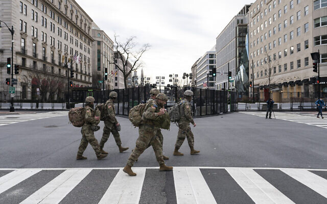 U.S. Army National Guard soldiers walk along K Street near Black Lives Matter Plaza, Tuesday, Jan. 19, 2021, in Washington. (AP Photo/Alex Brandon)