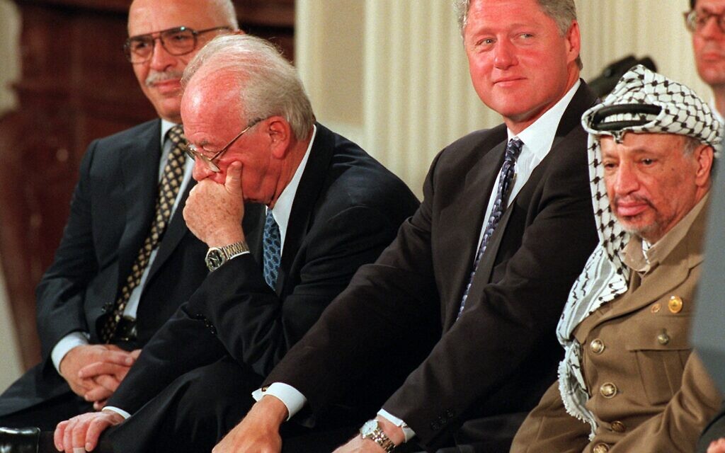 Israeli Prime Minister Yitzhak Rabin, second from left, holds his head in his hand during a Mideast accord signing ceremony, September 28, 1995, in the East Room of the White House. From left are, King Hussein of Jordan, Rabin, president Bill Clinton, and PLO leader Yasser Arafat. (AP Photo/Denis Paquin)