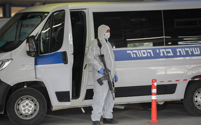 Prison guards wearing protective clothing transport a prisoner suspected of having the coronavirus, at Shaare Zedek Medical Center in Jerusalem, on March 30, 2020. (Yossi Zamir/Flash90)