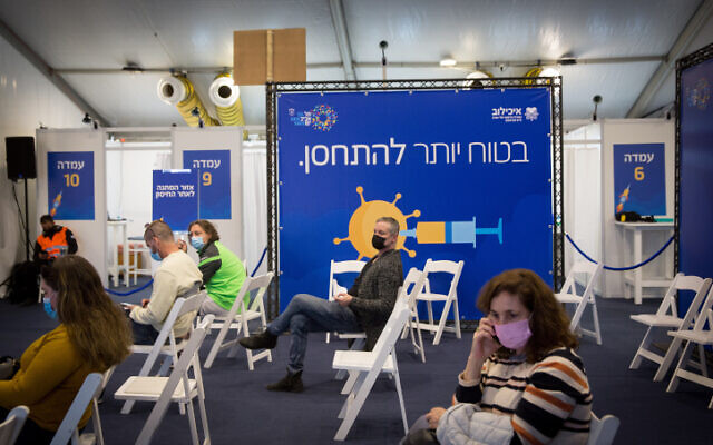 Israelis wait to receive a COVID-19 vaccine at a vaccination center operated by the Tel Aviv Municipality with Tel Aviv Sourasky Medical Center (Ichilov), at Rabin Square in Tel Aviv, December 31, 2020 (Miriam ALster/Flash90)