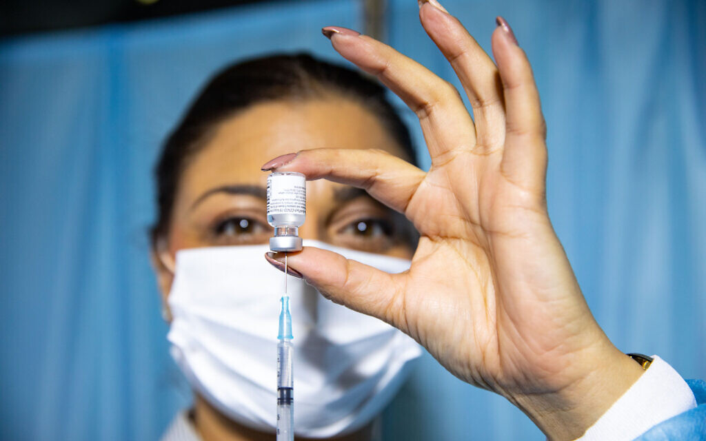 A health worker prepare a vaccination against COVID-19 at a Clalit vaccination center in Jerusalem, on December 31, 2020 (Olivier Fitoussi/Flash90)