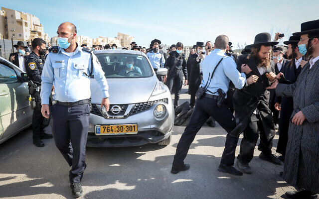 Ultra-Orthodox Jews clash with police as they protest the closure of a Talmud Torah that was operating in violation of lockdown orders, in the city of Beit Shemesh on January 12, 2021. (Yaakov Lederman/Flash90)