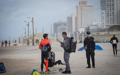 Police make sure kite surfers are keeping to the COVID-19 restrictions, on the beach in Tel Aviv, January 17, 2021. (Miriam Alster/Flash90)