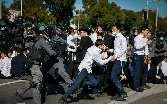 Ultra-Orthodox rioters clash with police after authorities closed a yeshiva that was operating in violation of lockdown orders, in the southern city of Ashdod, January 24, 2021. (Flash90)
