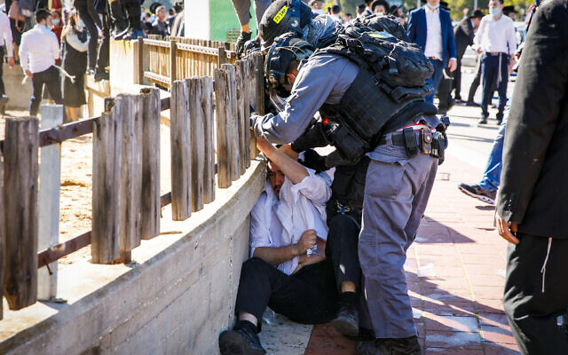 Ultra-Orthodox rioters clash with police after authorities closed a yeshiva that was operating in violation of lockdown orders, in the southern city of Ashdod, January 24, 2021. (Flash90)