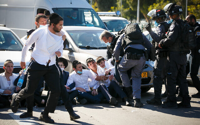 Ultra-orthodox Jews clash with police as they protest after authorities closed a yeshiva that was operating in violation of lockdown orders, in Ashdod, January 24, 2021 (Flash90)