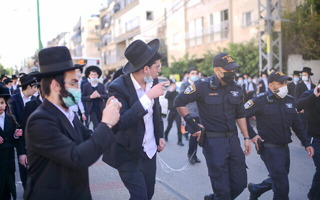 Police clash with Ultra orthodox rioters during a protest against the police enforcement of a lockdown orders due to the coronavirus, in the city of Bnei Brak, January 24, 2021. (Tomer Neuberg/Flash90)