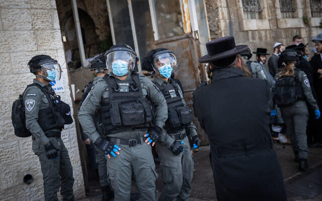 Israeli police officers clash with ultra-Orthodox men during enforcement of coronavirus emergency regulations, in Jerusalem, January 26, 2021 (Yonatan Sindel/Flash90)
