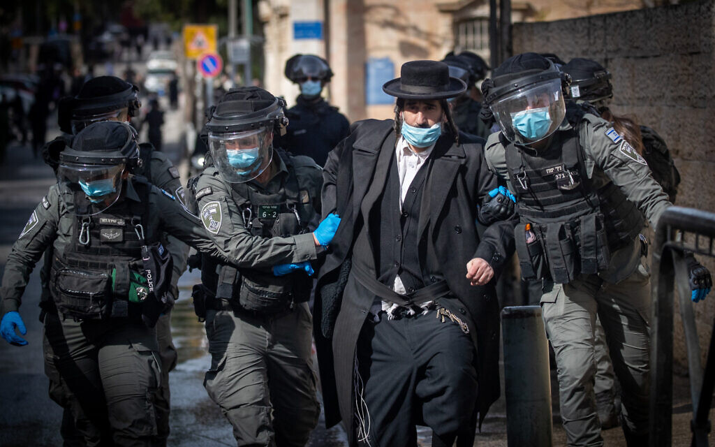 Police clash with Haredi men as they enforce coronavirus restrictions, in Jerusalem, January 26, 2021. (Yonatan Sindel/Flash90)