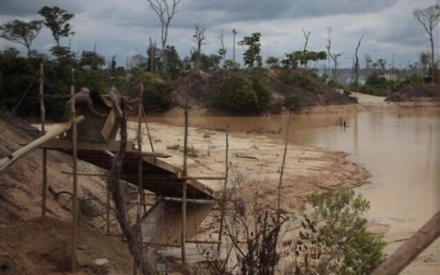 In this photo taken May 19, 2011, a miner works at an illegal mining process in Delta Uno, Madre de Dios, Peru. Mercury released by the mining is slowly poisoning people, plants, animals and fish, scientific studies show (AP Photo/Esteban Felix)