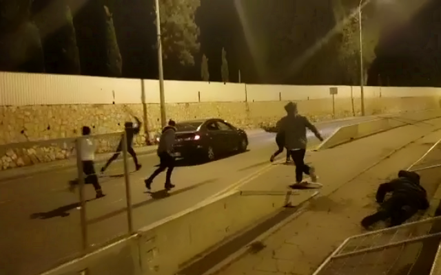 Demonstrators attack an Arab car in Jerusalem during a protest in the early hours of January 1, 2021. (Screenshot: Twitter)