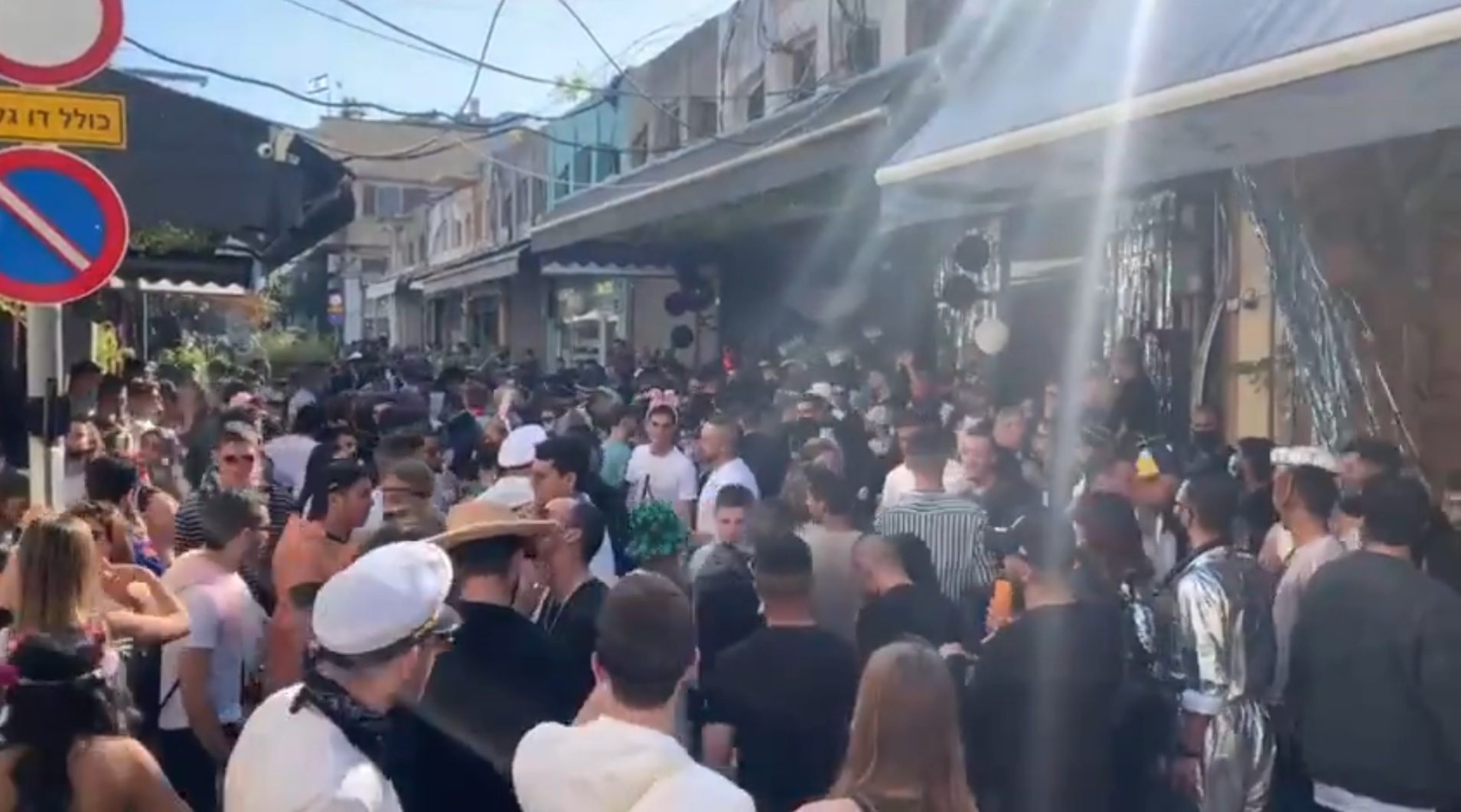 People celebrate the holiday of Purim in violation of coronavirus restrictions, at Jaffa’s Flea Market in Tel Aviv-Jaffa, February 27, 2021 (video screenshot)