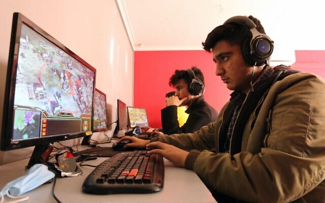 Young Iranians play an online multiplayer game at an internet cafe in Iran's capital Tehran on January 24, 2021. (Atta Kenare/AFP)