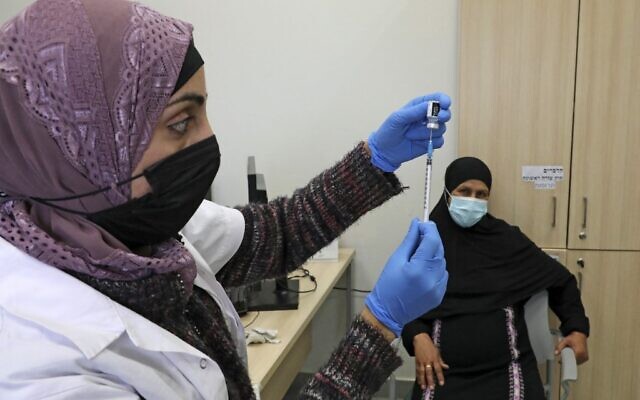 A healthcare worker prepares a shot of the Pfizer-BioNtech COVID-19 vaccine at a clinic in the Negev's main Bedouin town of Rahat, on February 17, 2021. (HAZEM BADER / AFP)