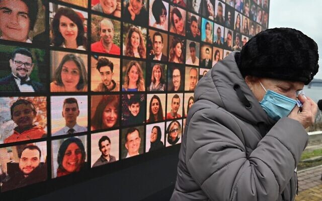 In this file photo taken on January 08, 2021 a woman cries in front of a huge screen bearing portraits of late crew members and passengers of Ukraine International Airlines Flight 752, which crashed in Iran a year before, during a commemorative ceremony at the site of a future memorial on the Dnipro river bank in Ukraine's capital Kiev (Genya SAVILOV / AFP)