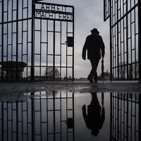 Illustrative: A man walks through the gate of the Sachsenhausen Nazi death camp with the phrase 'Arbeit macht frei' (work sets you free) during International Holocaust Remembrance Day in Oranienburg, about 30 kilometers (18 miles), north of Berlin, Germany. (AP Photo/Markus Schreiber, file)