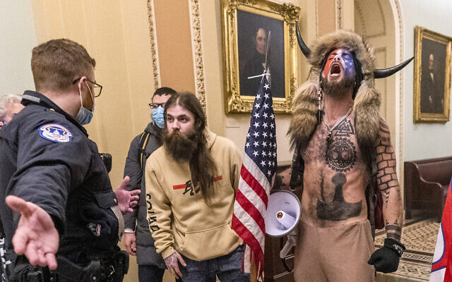 In this Wednesday, Jan. 6, 2021 file photo, supporters of President Donald Trump, including Jacob Chansley, right with fur hat, are confronted by US Capitol Police officers outside the Senate Chamber inside the Capitol in Washington. (AP Photo/Manuel Balce Ceneta)