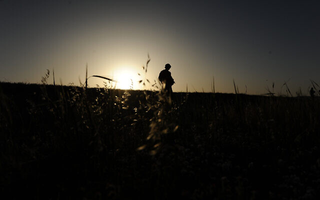 An IDF soldier seen silhouetted as he is walking through the fields near his army base, in Beersheba, southern Israel, March 31, 2014 (Mendy Hechtman/FLASH90)