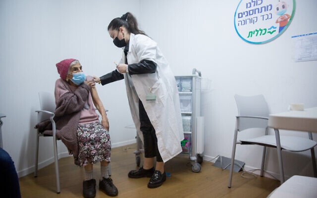 Illustrative: An elderly woman receives a COVID-19 vaccine, at a vaccination center in Tel Aviv, January 21, 2021 (Miriam Alster/Flash90)