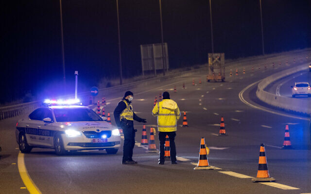 Police put up a temporary roadblock on Route 1 near Jerusalem during a nighttime curfew for the Jewish holiday of Purim, February 25, 2021 (Yonatan Sindel/Flash90)