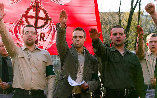 Tomasz Greniuch, in the center holding papers, makes a gesture that appears to be a Nazi salute at a far-right event in Poland in 2007. (Bartosz Siedlik, courtesy of Gazeta Wyborcza via JTA)
