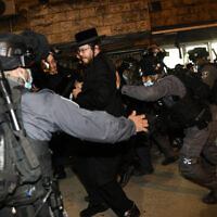 Illustrative: Ultra-Orthodox men clash with police during a protest against coronavirus restrictions in Jerusalem, February 9, 2021. (Noam Revkin Fenton/Flash90)