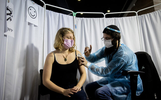 An Israeli receives a COVID-19 vaccine in Jerusalem, February 10, 2021. (Yonatan Sindel/Flash90)