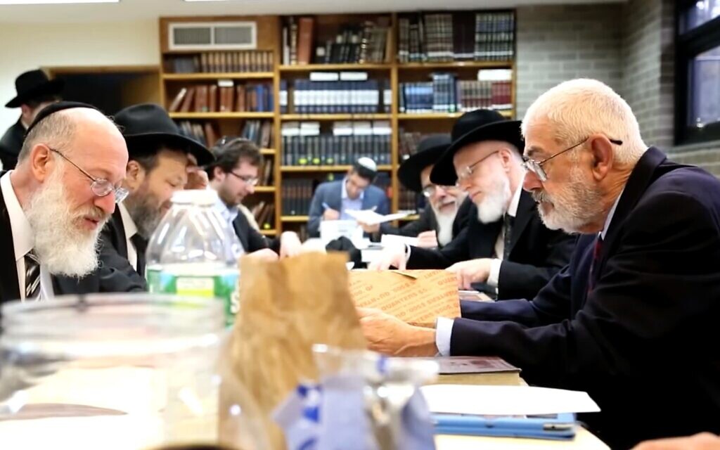 Rabbi Mordechai Willig, left, executes the 2015 sale of hametz to John J. Brown, right. (Josh Weinberg/ screenshot from YouTube/ via JTA)