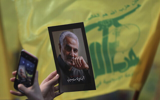 Illustrative: A supporter of the Hezbollah terror group uses her mobile phone to takes a picture of photo of slain Iranian Revolutionary Guard Gen. Qassem Soleimani during a ceremony marking the anniversary of the assassination of Hezbollah leaders, Abbas al-Moussawi, Ragheb Harb and Imad Mughniyeh and the end of a 40-day Muslim mourning period for Soleimani, in the southern suburb of Beirut, Lebanon, February 16, 2020. (AP Photo/Hassan Ammar)