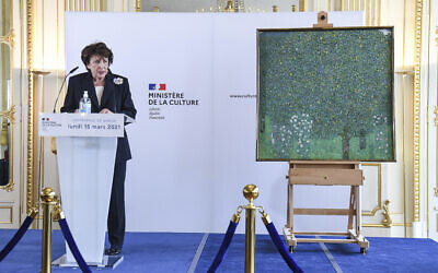 French Culture Minister Roselyne Bachelot poses next to an oil painting by Gustav Klimt painted in 1905 called 'Rosebushes under the Trees,' during a ceremony at the Orsay museum in Paris, March 15, 2021. (Alain Jocard/Pool Photo via AP)