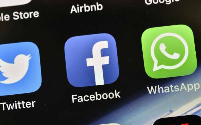Illustrative: Icons of Facebook and WhatsApp are pictured on an iPhone. (AP/Martin Meissner)