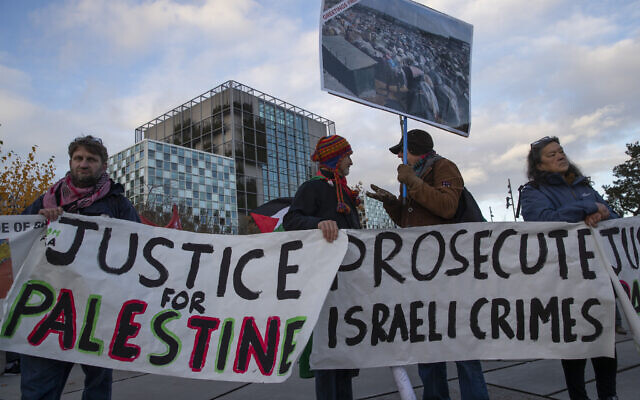 Demonstrators carry banners outside the International Criminal Court, ICC, rear, urging the court to prosecute Israel's army for alleged war crimes, The Hague on Nov. 29, 2019. (AP/Peter Dejong)