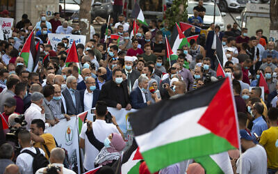 Palestinians wave national flags during a protest against normalization of ties between the United Arab Emirates and Bahrain with Israel, in the West Bank city of Ramallah, September 15, 2020. (Majdi Mohammed/AP)