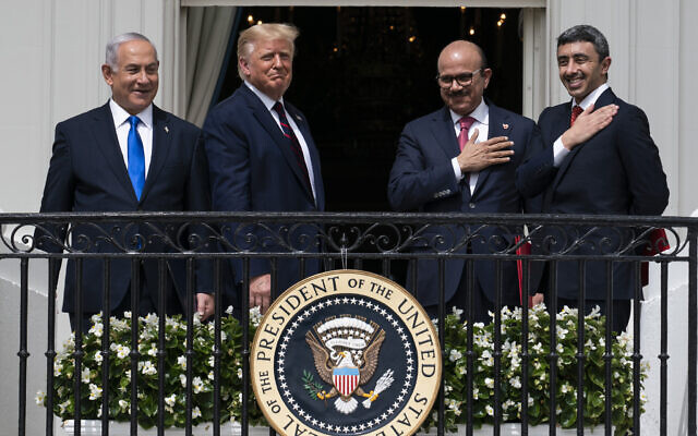 Then-prime minister Benjamin Netanyahu, left, then-US president Donald Trump, Bahrain Foreign Minister Khalid bin Ahmed Al Khalifa and United Arab Emirates Foreign Minister Abdullah bin Zayed al-Nahyan react on the Blue Room Balcony after signing the Abraham Accords during a ceremony on the South Lawn of the White House in Washington, September 15, 2020. (AP Photo/Alex Brandon)