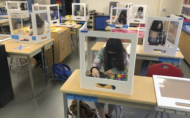 Socially distanced and with protective partitions students work on an art project during class at the Sinaloa Middle School in Novato, California on March 2, 2021 (AP Photo/Haven Daily)