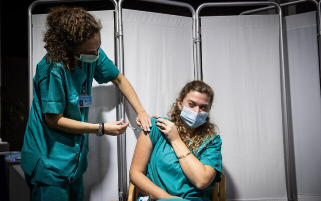 A Hadassah medical staff member receives the second round of a COVID-19 vaccine, on January 11, 2021. (Yonatan Sindel/Flash90)