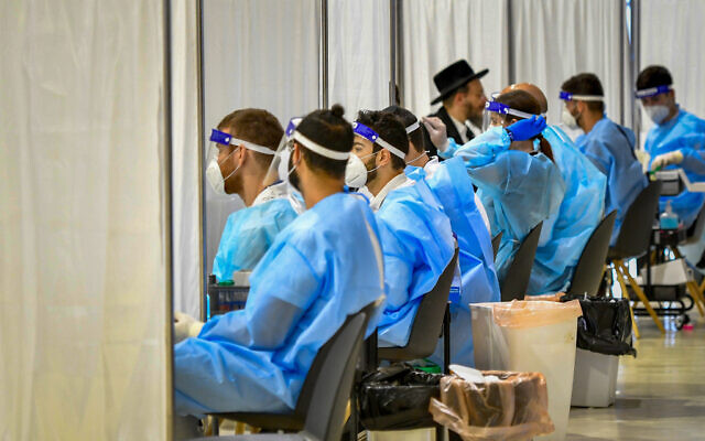 Medical technicians test passengers for COVID-19 at the Ben Gurion International Airport near Tel Aviv on March 8, 2021 (Avshalom Sassoni/Flash90)