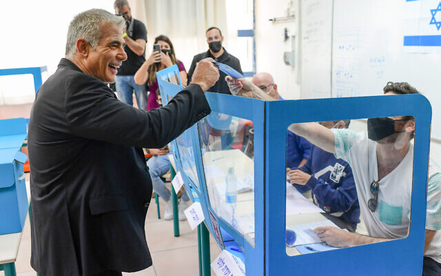 Yesh Atid party leader Yair Lapid casts his ballot at a voting station in Tel Aviv on March 23, 2021. (Tomer Neuberg/Flash90)