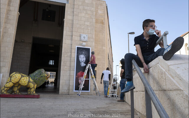Hanging photographic portraits of Holocaust survivors that are part of The Lonka Project being exhibited in Safra Square in Jerusalem, opening April 8, 2021, Yom HaShaoh, Israeli Heroes and Martyrs remembrance  day, and will run for four months, until at least August 2021 (Courtesy The Lonka Project)